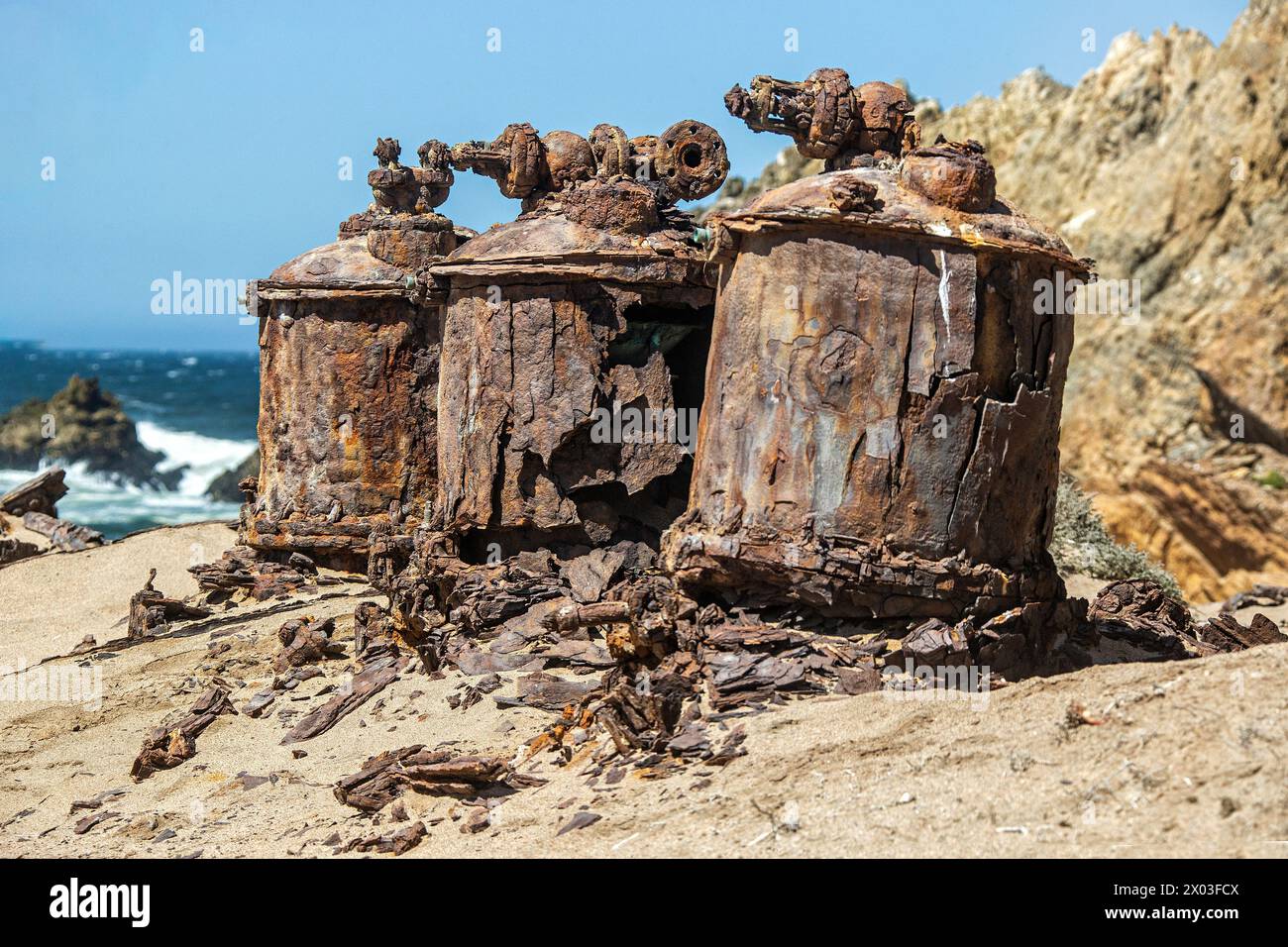 Rusted remains of the desalination plant by the Bogenfels Rock Arch in Namibia. Stock Photo