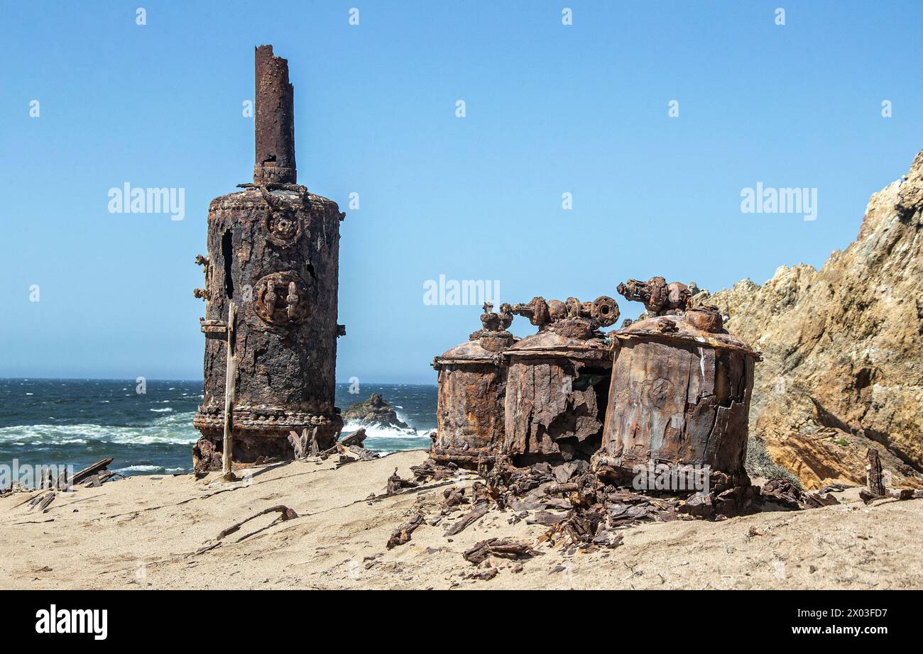 Rusted remains of the desalination plant by the Bogenfels Rock Arch in Namibia. Stock Photo