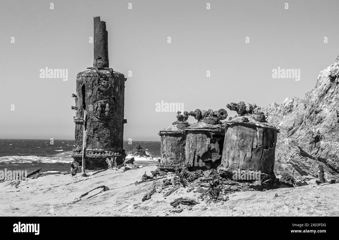 Rusted remains of the desalination plant by the Bogenfels Rock Arch in Namibia. Stock Photo