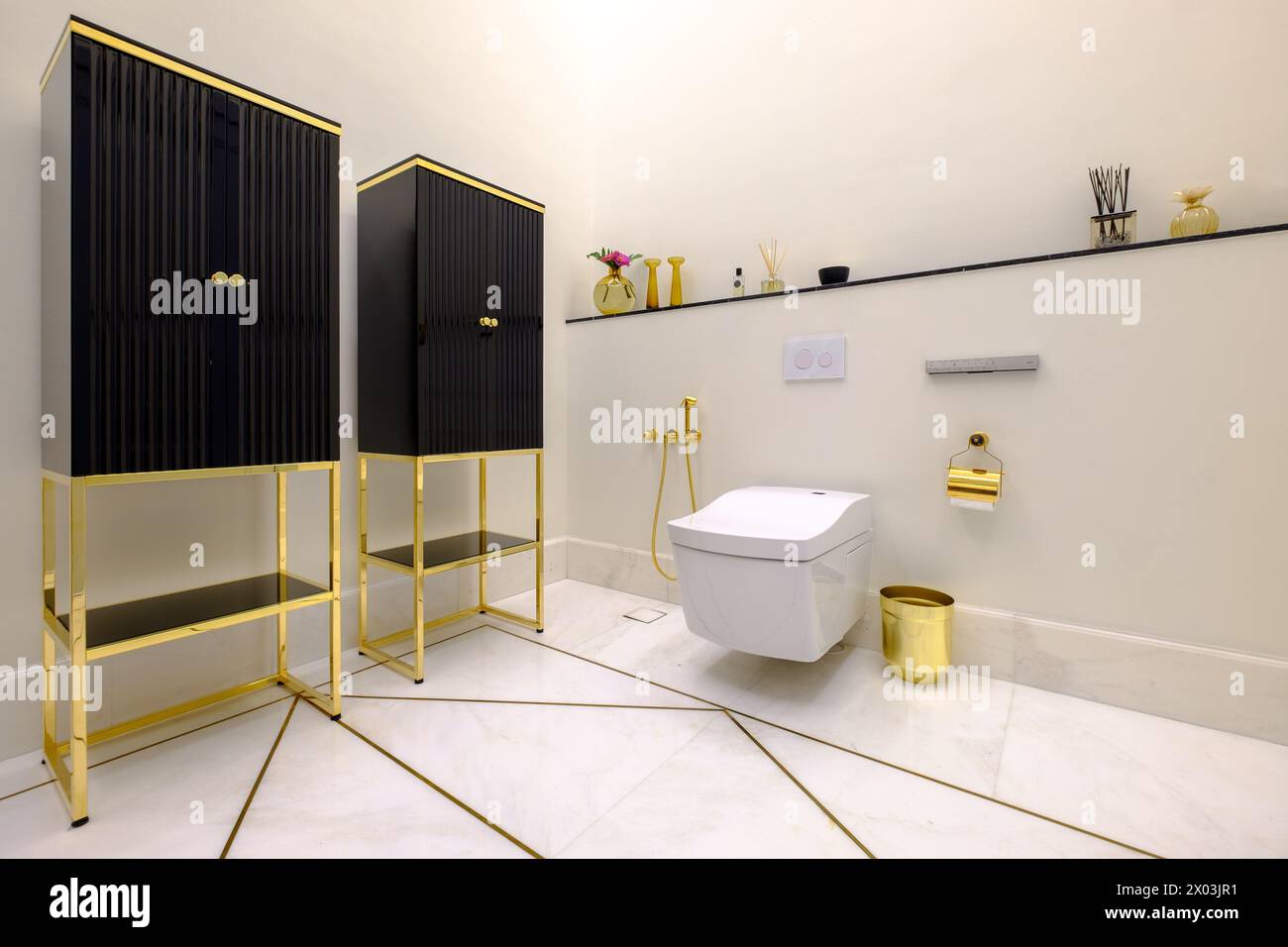 HAMALA, BAHRAIN - MARCH 02, 2019: Elegant modernist toilet with marble floor and gold fittings in a bathroom of a luxury villa. Stock Photo