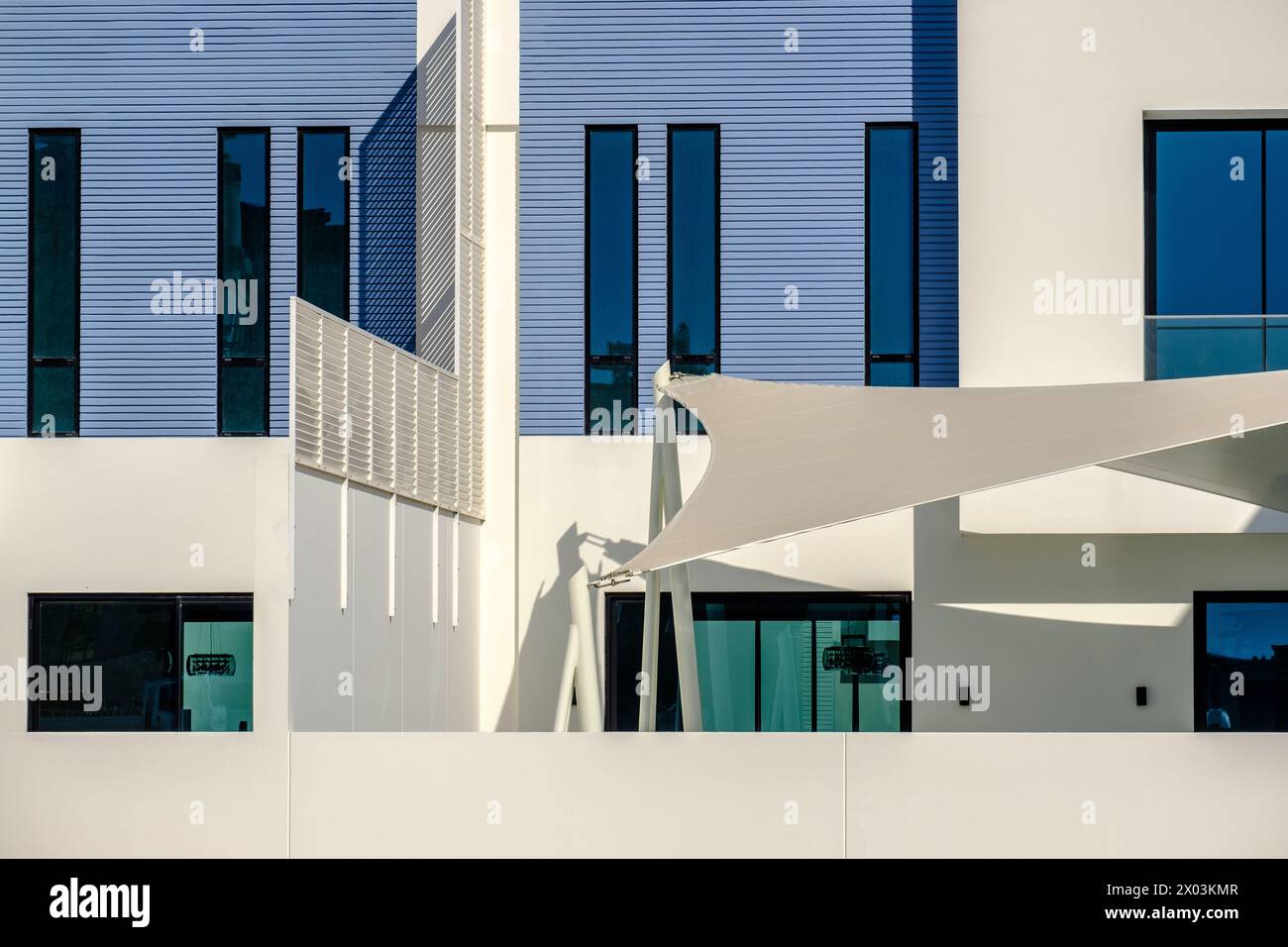 Detail of white and blue modern villas in a Middle Eastern, high-end, luxury housing development on a sunny day with strong shadows. Stock Photo