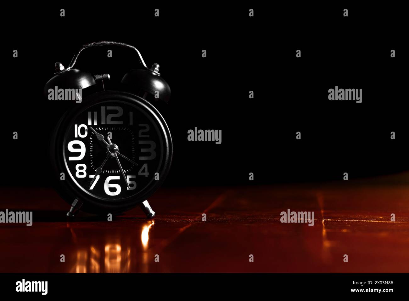 Black retro alarm clock on wooden table Stock Photo
