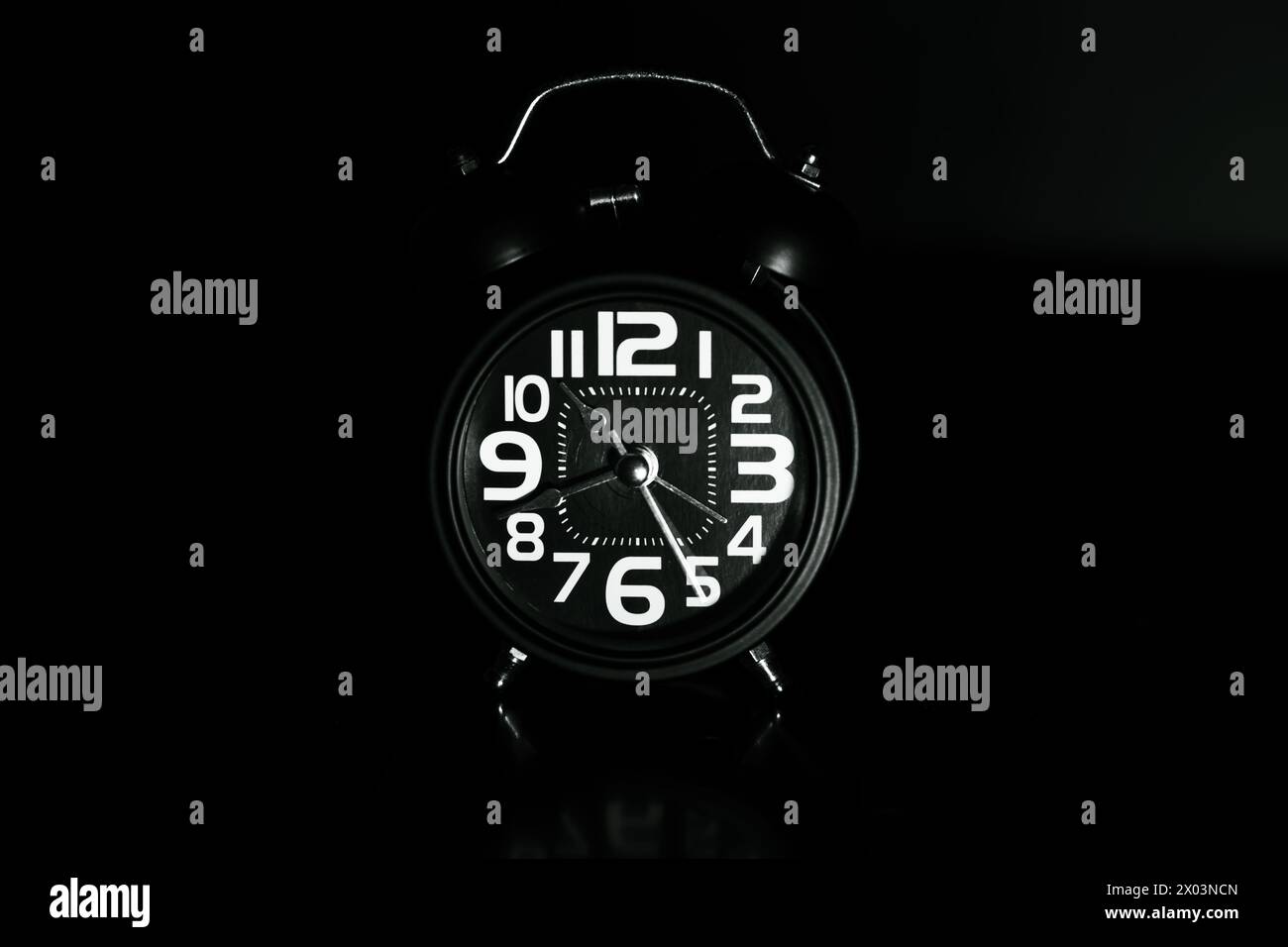 Close up of Black retro alarm clock on dark background Stock Photo