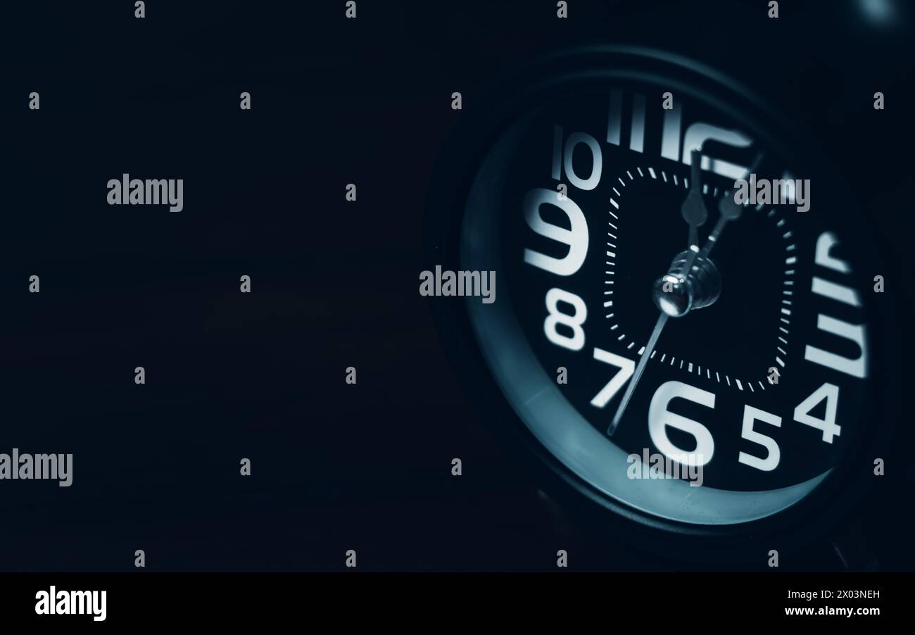 Close up of Black retro alarm clock on dark background Stock Photo