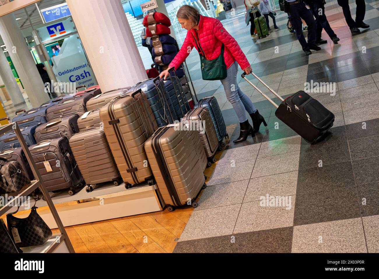 Los geht die Reise. Eine Frau beim Kofferkauf am Flughafen in München