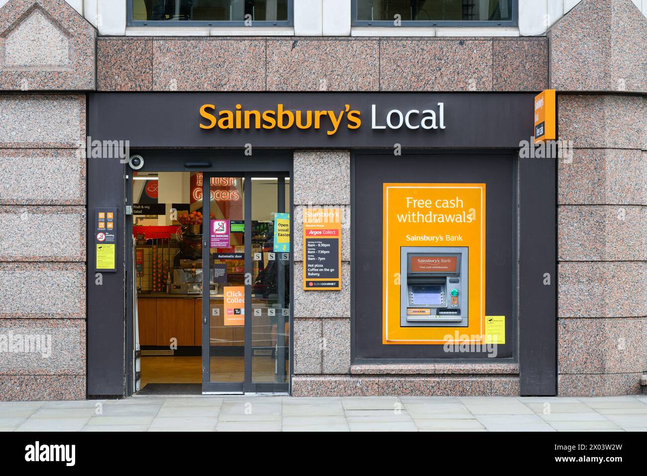 London, UK - March 25, 2024; Facade and entrance with ATM at Sainsbury's Local convenience shop Stock Photo