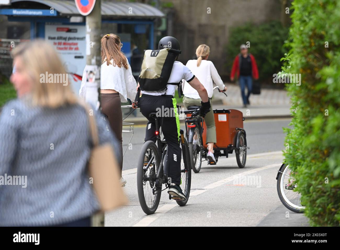 Radfahrer fahren mit ihren Raedern,Fahrraedern auf einem Radweg in Muenchen im Stadtverkehr,Rad fahren. Lastenrad. *** Cyclists riding their bikes, bicycles on a bike path in Munich in city traffic, cyclists riding cargo bikes Stock Photo