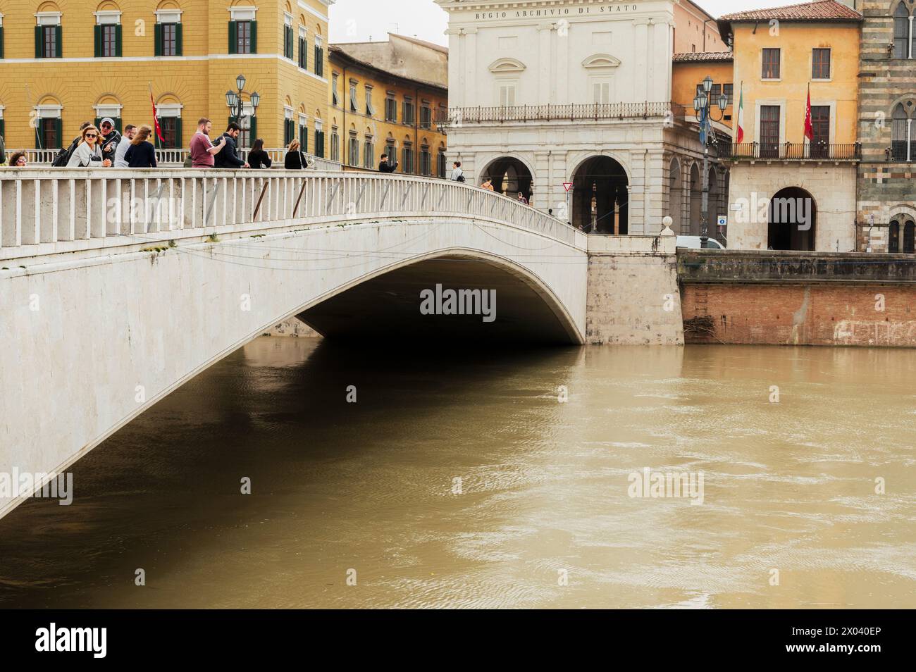 Overview of the Arno river flowing in the city of Pisa between old historic buildings, March 2024 (Tuscany, Italy) Stock Photo