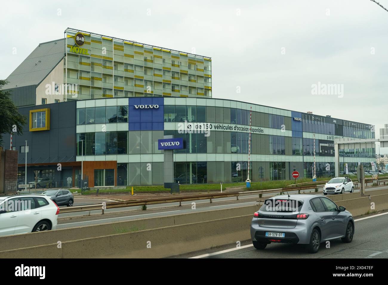 Lyon, France - May 16, 2023: The facade of a Volvo car dealership, with vehicles displayed behind large glass windows and a Volvo sign prominently fea Stock Photo