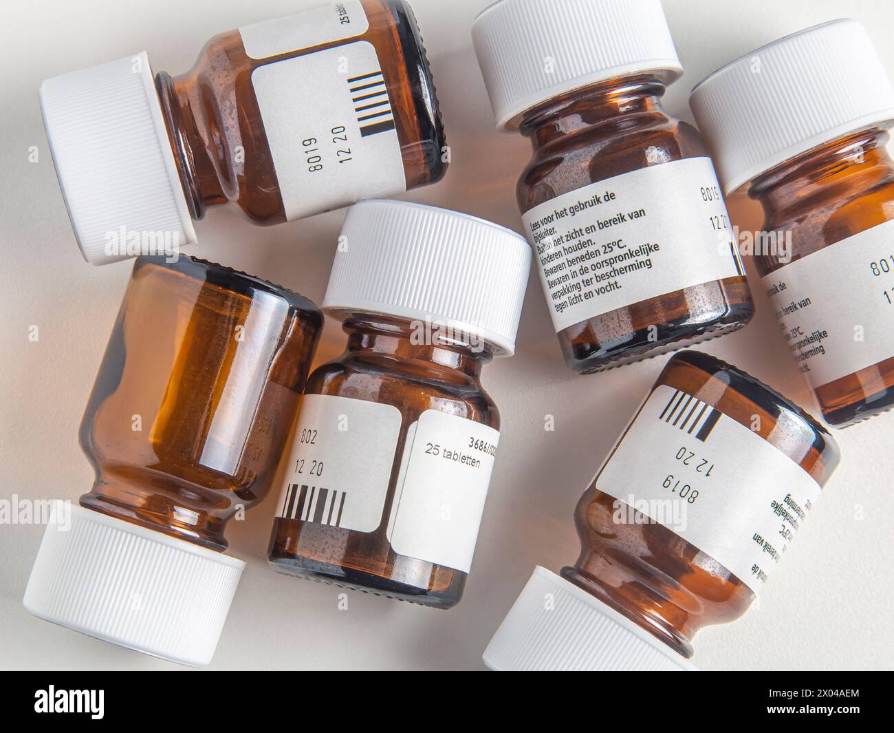 Used glass pill bottles on white surface Stock Photo