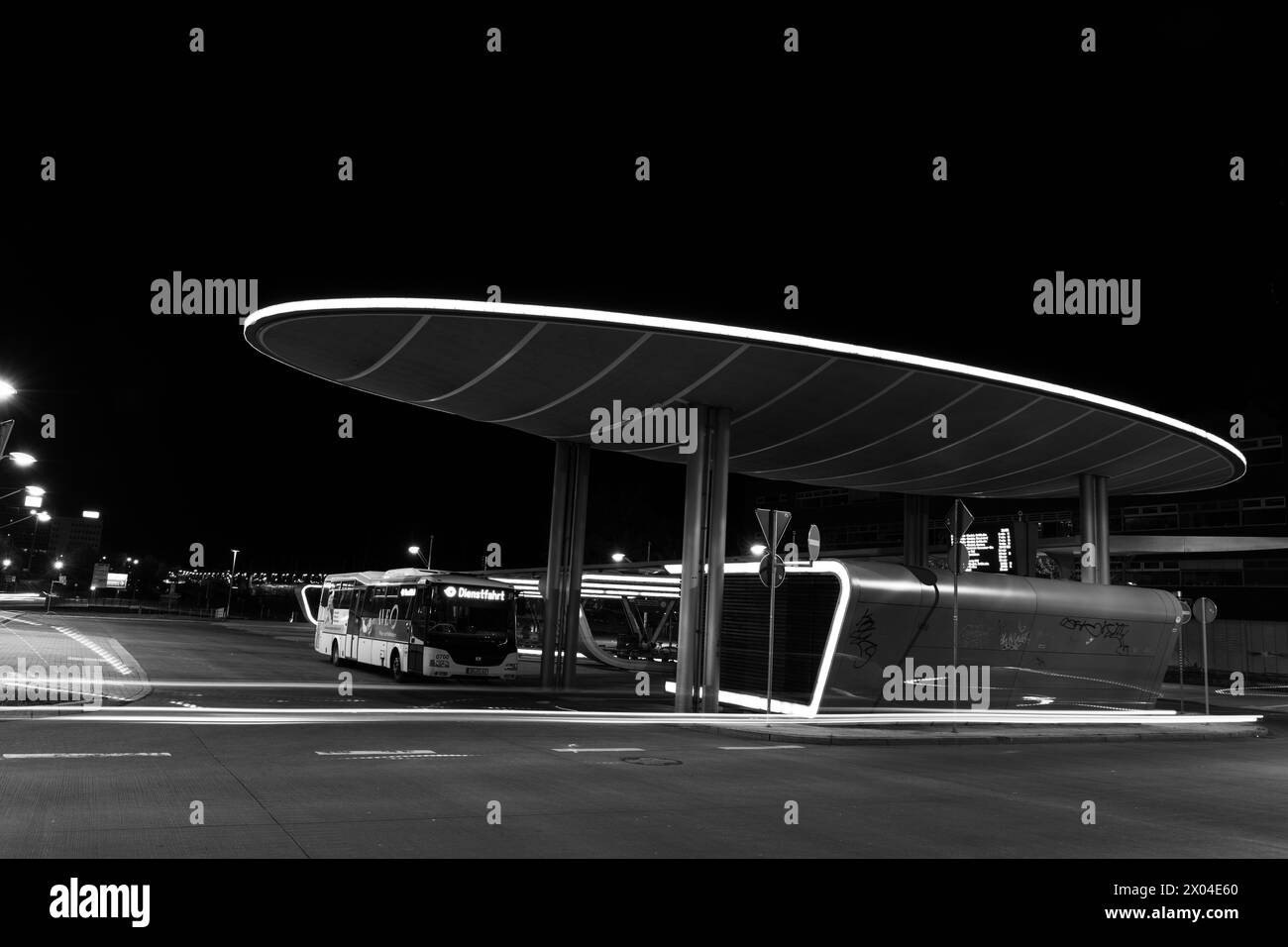 illuminated modern central bus station in Halle at night in a black and white picture Stock Photo