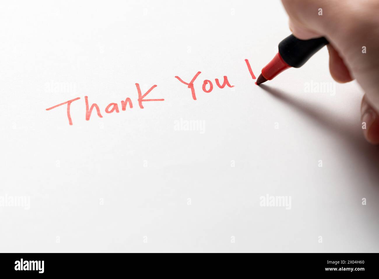 Hand written thank you message with a red pen on white background, gratitude concept. Stock Photo