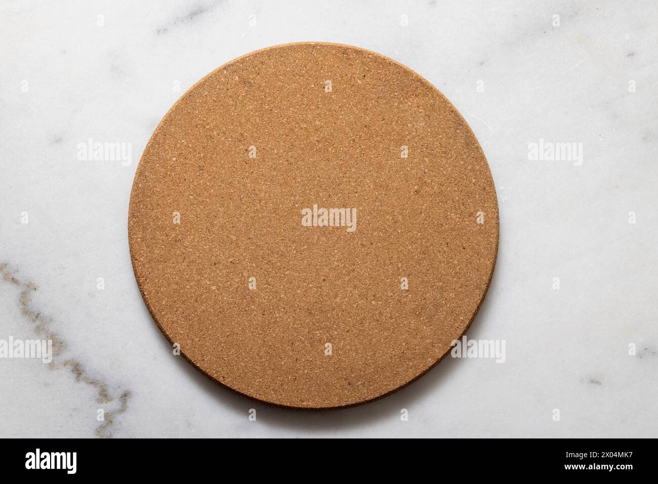 Marble kitchen counter with a round cork trivet mat for hot pans and