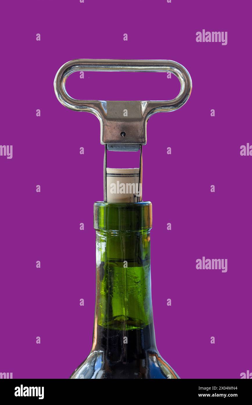 Two prong cork puller and cork halfway pulled from green wine bottle