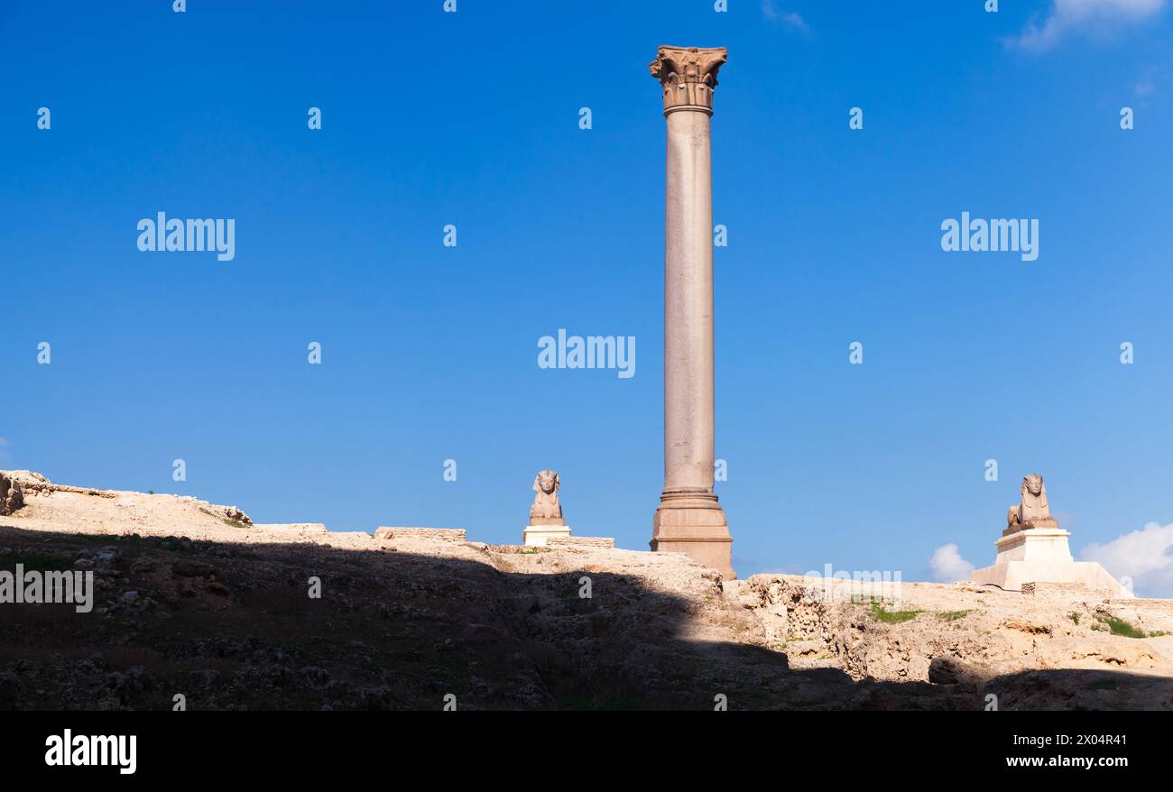 Alexandria, Egypt. Ancient stone sphinxes stand near the Pompeys Pillar ...