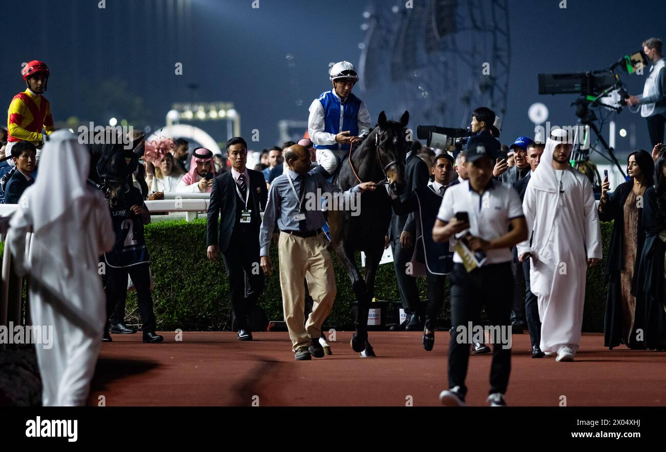 Junko and Maxime Guyon head to the start for the Group 1 Longines Dubai Sheema Classic, Meydan Racecourse, 30/03/24. Credit JTW Equine Images / Alamy. Stock Photo