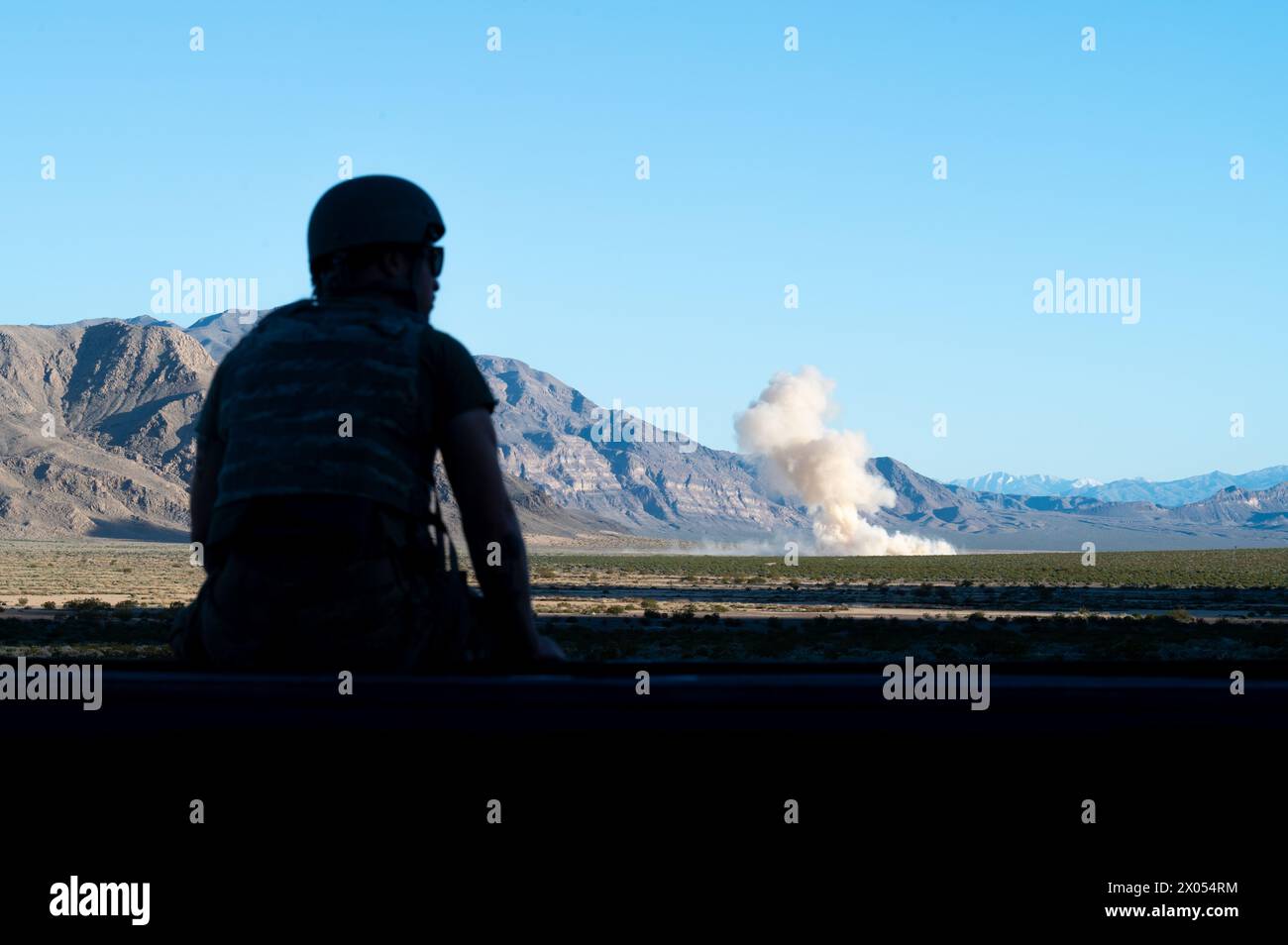 A U.S. Airman assigned to the 757th Aircraft Maintenance Squadron watches an explosion during a Joint Terminal Attack Controller proficiency training at the Nevada Test and Training Range, April 2, 2024. Several munitions including air-to-ground 65 Maverick missiles, guided bomb unit (GBU) 39 small diameter bombs and GBU-31 joint direct attack munitions were dropped during the training. (U.S. Air Force photo by Senior Airman Jose Miguel T. Tamondong) Stock Photo