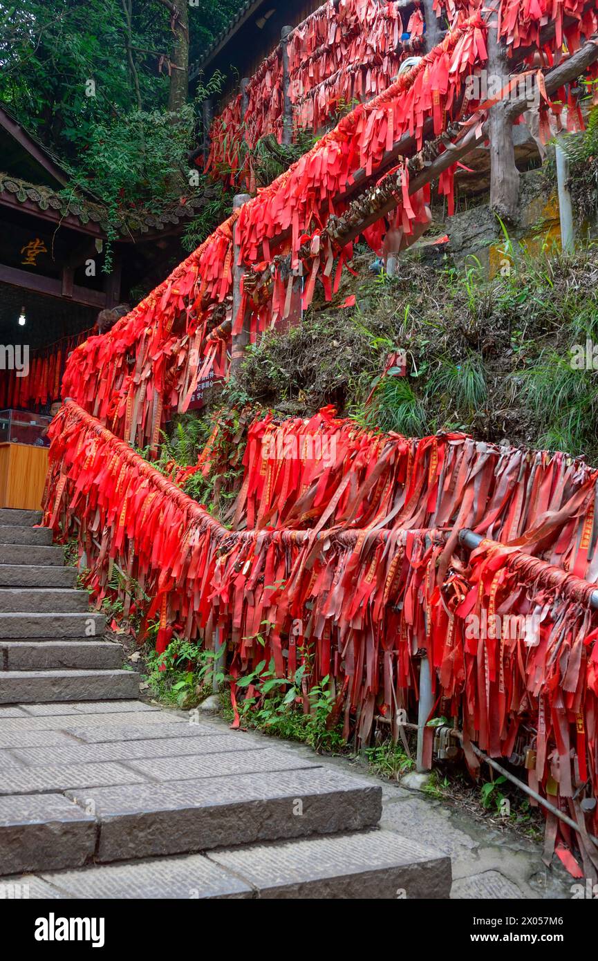 Red blessing ribbons tied to handrails line a stairway in Zhangjiajie ...