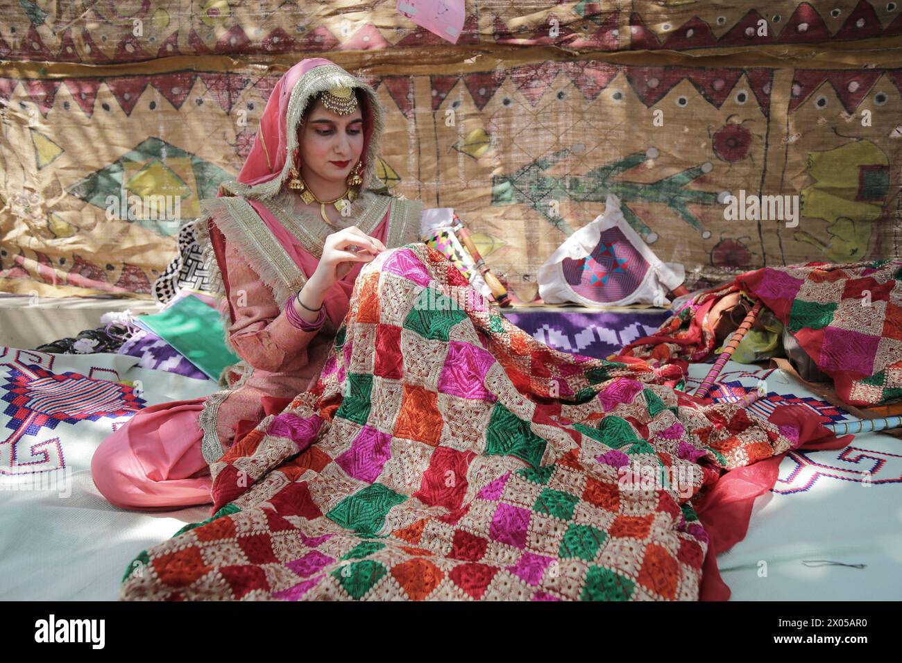 Amritsar. 9th Apr, 2024. A woman wearing traditional Punjabi attire sews a traditional Punjabi women wear during a fair celebrating the Baisakhi festival at a college in Amritsar district of India's northern Punjab state, April 9, 2024. Baisakhi is one of the most popular festivals celebrated in the Indian state of Punjab to mark the harvest. Credit: Str/Xinhua/Alamy Live News Stock Photo