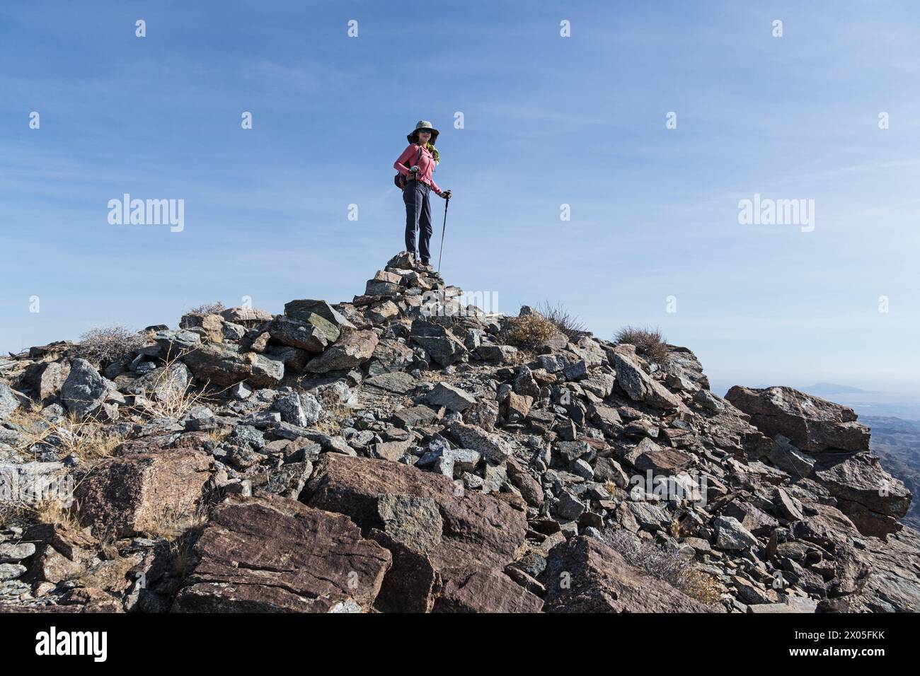 woman day hiker standing on the summit cairn of the Whipple Mountains high point Stock Photo