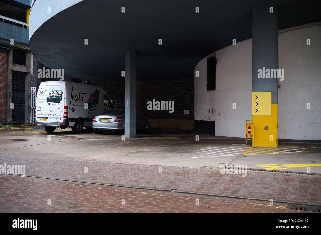 10 mar 2024 - worcesteruk : entrance to city car park with circular ramp and single car and single van Stock Photo