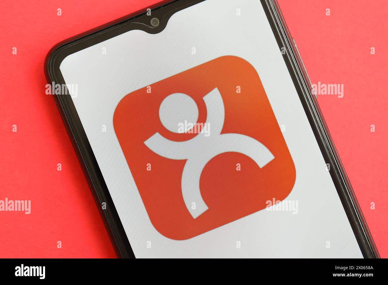 KYIV, UKRAINE - APRIL 1, 2024 Dianping platform icon on smartphone screen on red table close up. iPhone display with app logo on bright red background Stock Photo