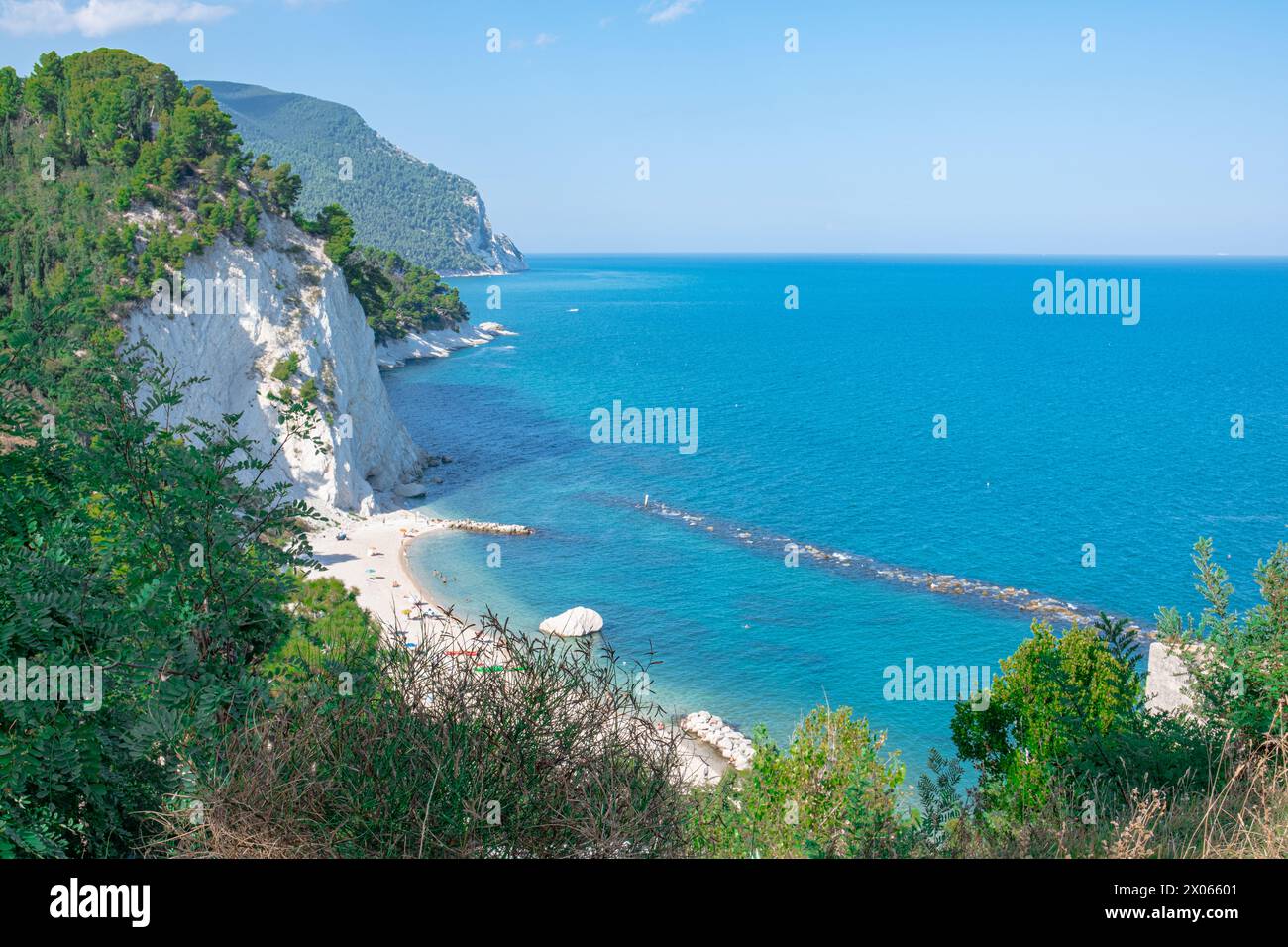 Beach of the Two Sisters in Italy, Numana. Beautiful view of the popular sea beach. Pines and other vegetation on the shore and blue water, and above Stock Photo