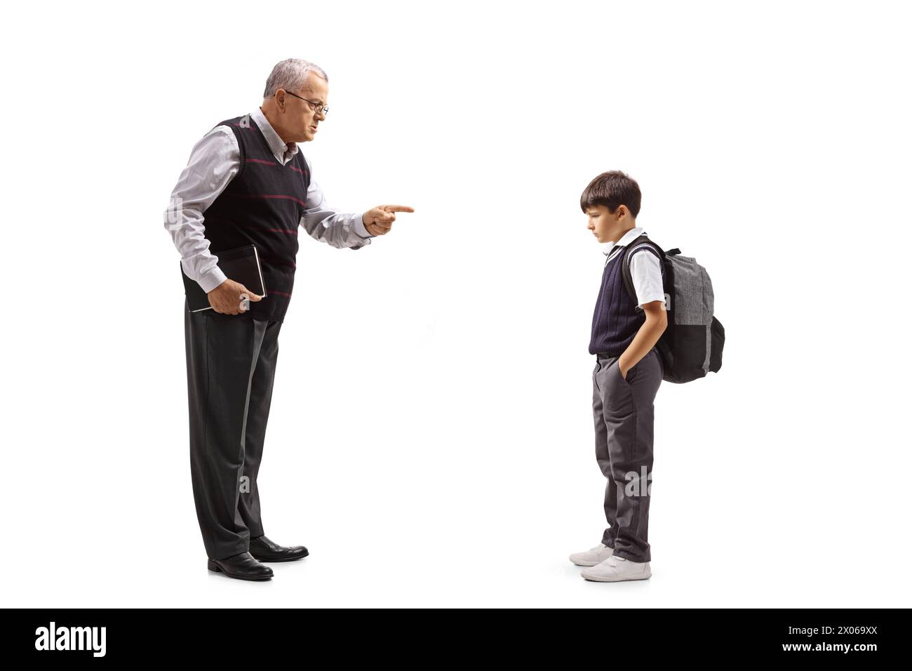 Full length profile shot of a strict male teacher reprimanding a schoolboy isolated on white background Stock Photo