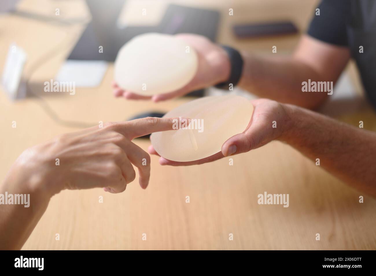 Female hand picks silicone implants for breast augmentation. Stock Photo