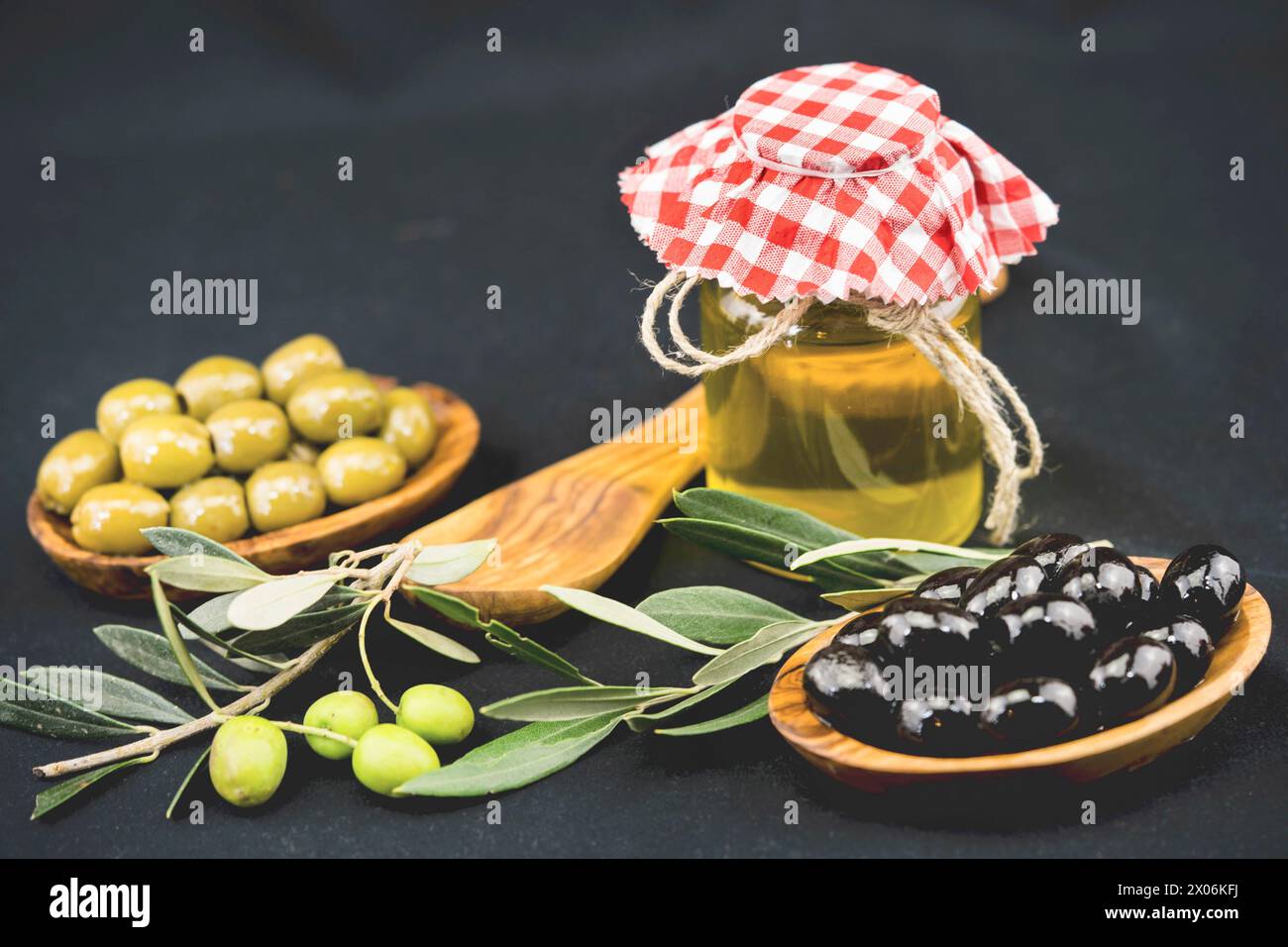 Fresh and pickled olives with wooden spoon, and jar of olive oil Stock ...