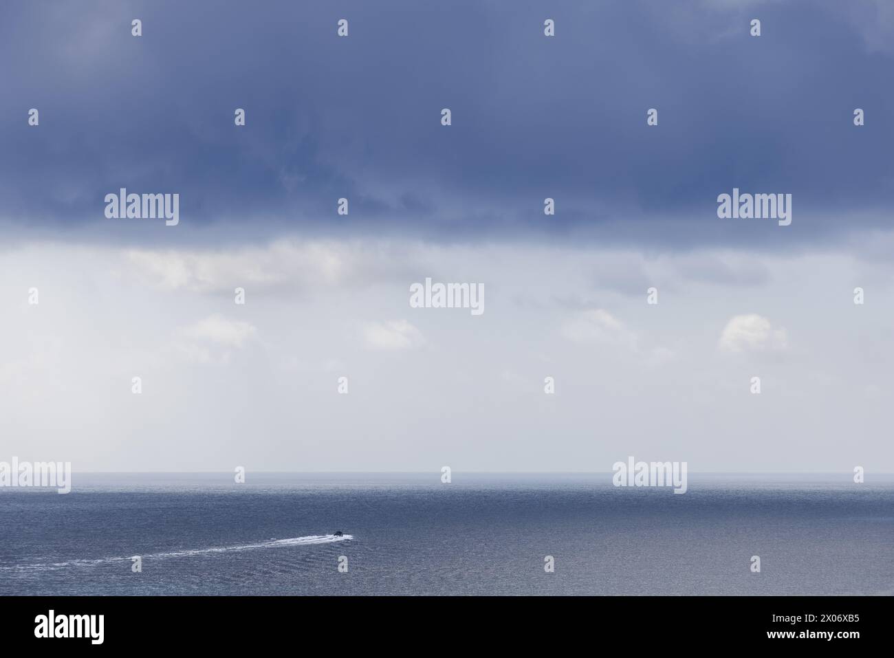 Under a canopy of gathering storm clouds, a lone speedboat ventures ...