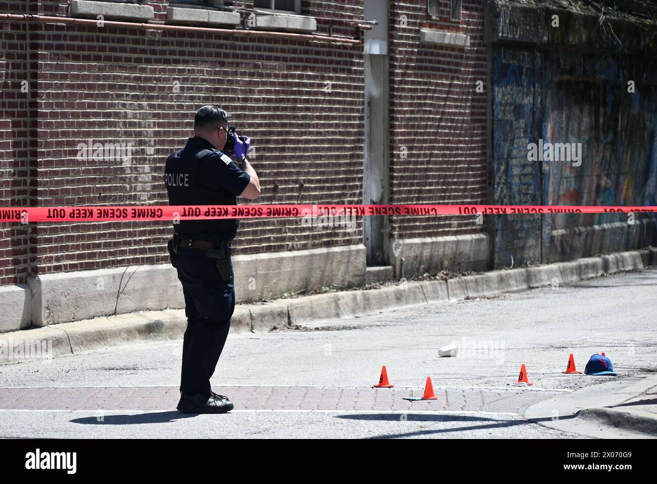 A Police officer from the Chicago Police Department photographs the ...