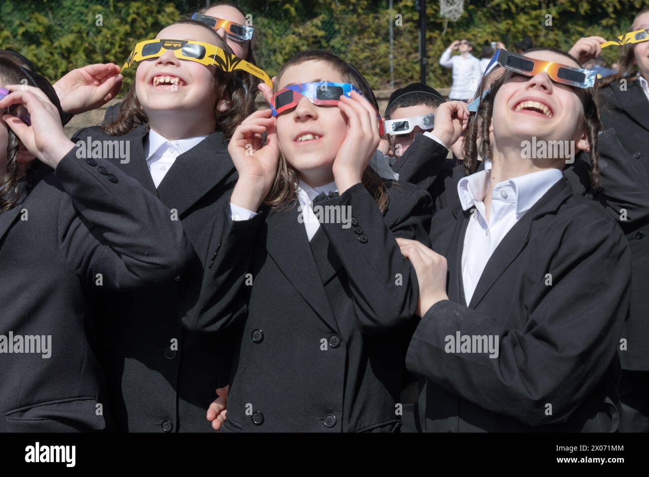 3 orthodox Jewish yeshiva students watch the 2024 Solar eclipse in