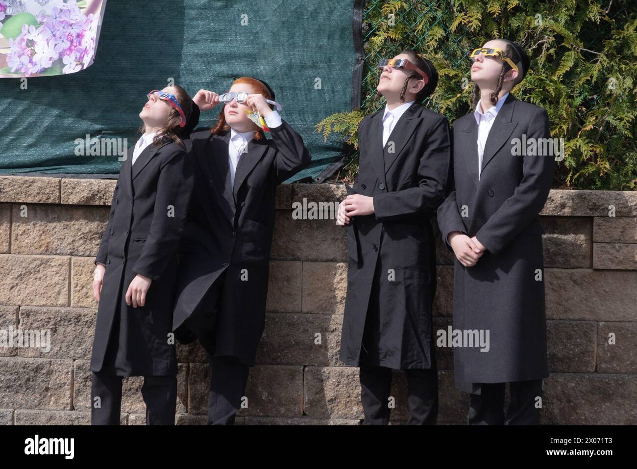 In their schoolyard, 4 orthodox Jewish students watch the 2024 Solar