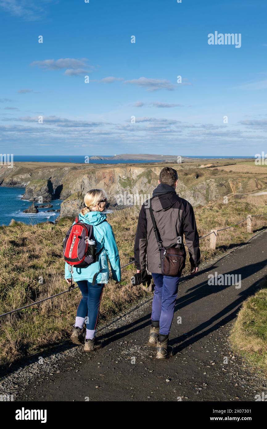 Walkers walking along the clifftop path at Bedruthan Steps in Cornwall in England in the UK. Stock Photo