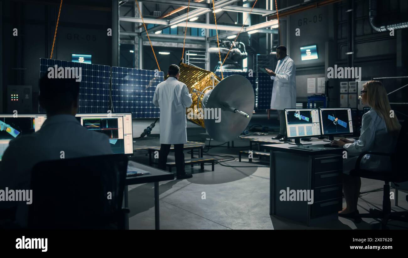 Team of Engineers Working on Satellite Construction. Aerospace Agency Spaceship Manufacturing Factory: Diverse Group of Multi-Ethnic Scientists Developing Spacecraft for International Space Program. Stock Photo