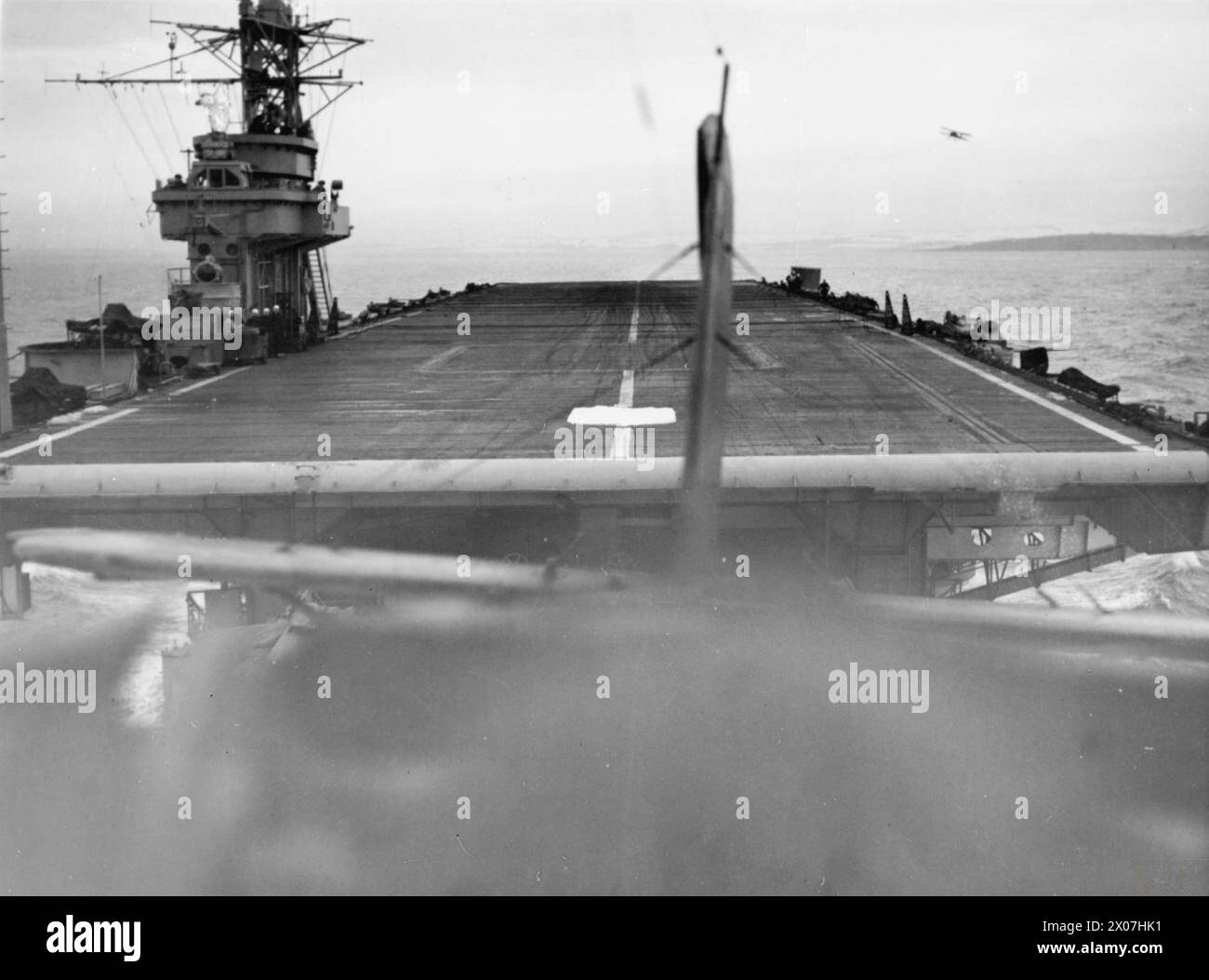 WITH THE ESCORT CARRIER HMS SMITER. 1944, AT SEA, ON BOARD A FAIREY SWORDFISH OF THE CARRIER DURING THE TRAINING OF DECK LANDING CONTROL OFFICERS, WHEN AIRCRAFT WERE TAKING OFF AND LANDING ON. - Looking back from a Fairey Swordfish as it took off from the SMITER Stock Photo
