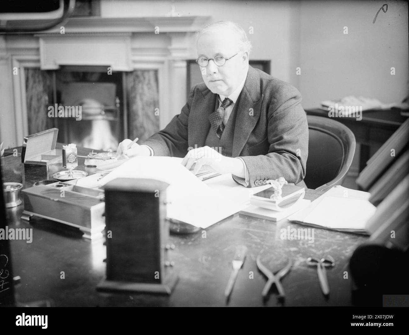 THE AIR MINISTRY, 1939-1945. - Sir Kingsley Wood, the Secretary of State for Air, sitting at his desk in the Air Ministry  Wood, Kingsley, Air Ministry Stock Photo