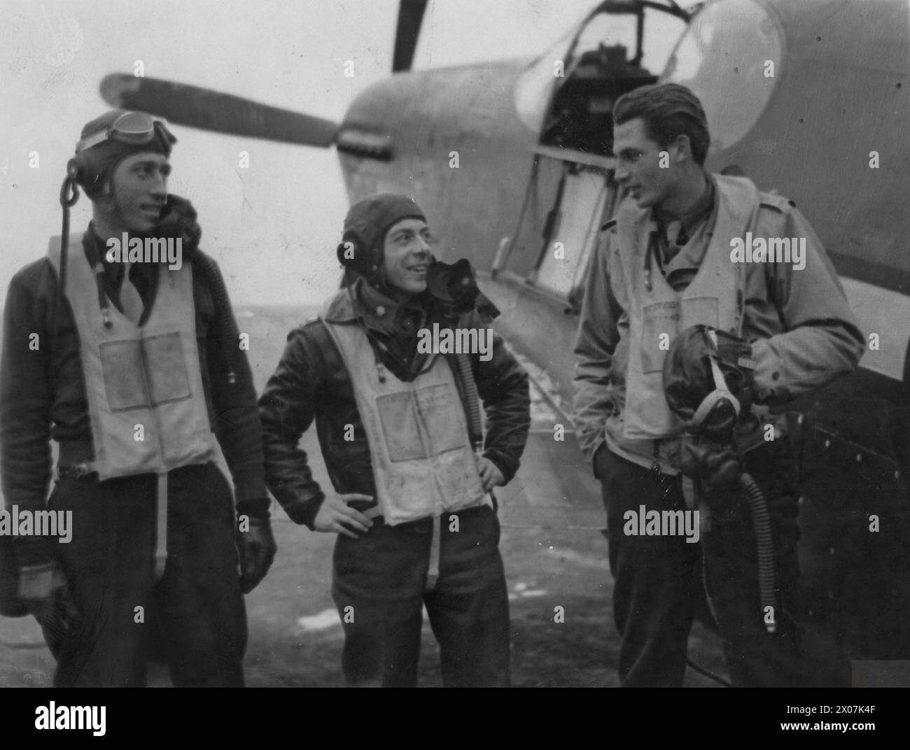 UNITED STATES NINTH AIR FORCE IN BRITAIN, 1942-1945 - Squadron Commanders of the 354th Fighter Group, Major James H Howard, Major George R Bickell and Major Owen M Seaman, with a P-51 Mustang.Image stamped on reverse: 'Associated Press.' [stamp], 'Passed for publication 13 Jan 1944.' [stamp] and '296905.' [Censor no.]Printed caption on reverse: 'THE P-51B- WORLD'S FASTEST FIGHTER PLANE. Associated Press photo shows: The three Squadron Commanders of the group. Left to right: Major James H Howard, aged 30, of 30 Crestwood Drive, St Louis, MO; Major George R Bickell, aged 27, of [obscured] Nutten Stock Photo