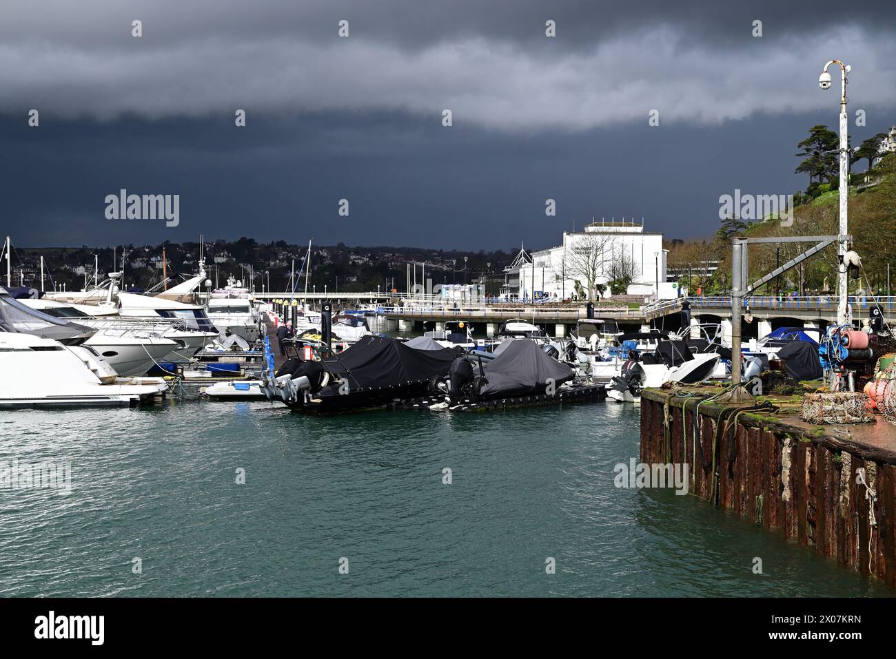 Sunshine and dark clouds over boats in Torquay harbour, as rain approaches. Stock Photo
