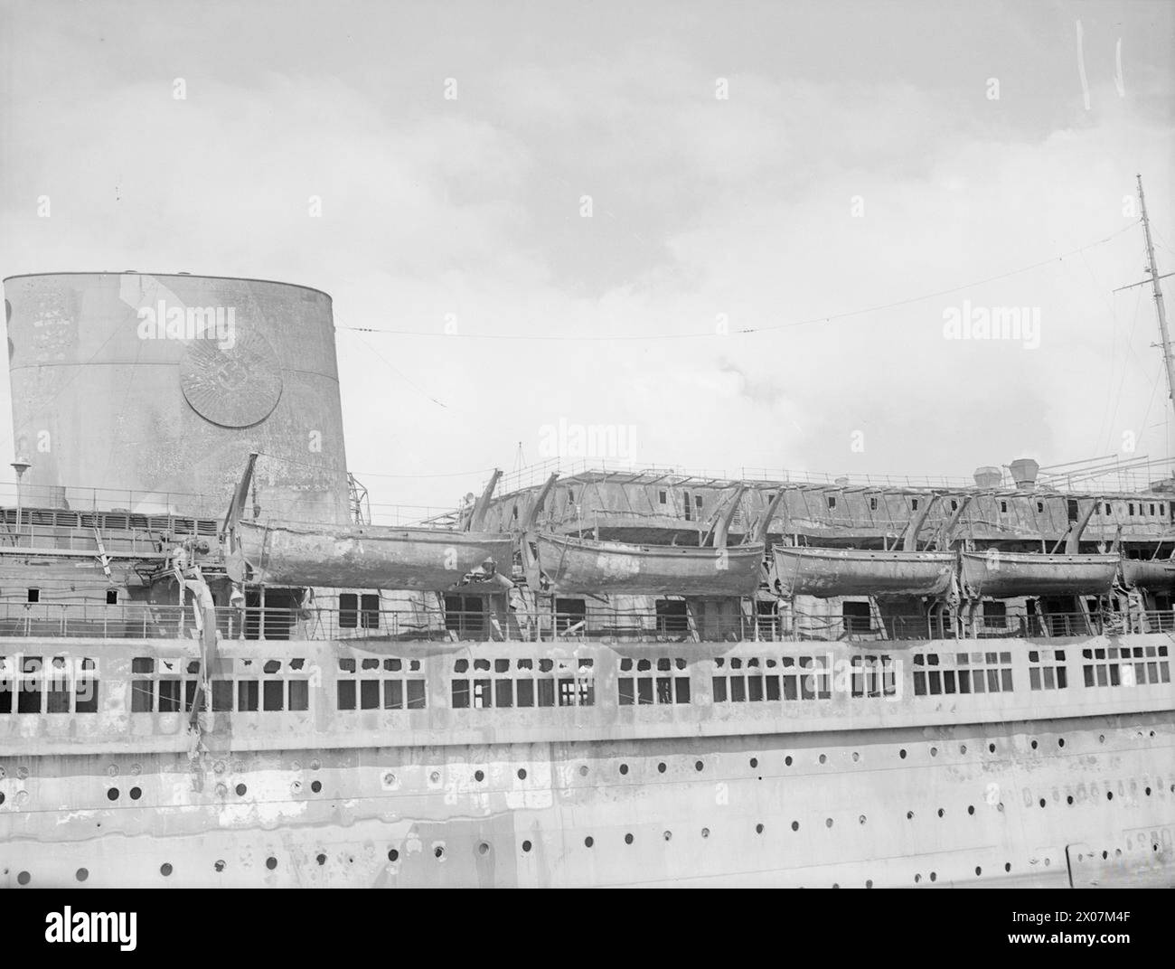 WRECKAGE IN THE BOMB-SCARRED HAMBURG DOCKS. 8 JULY 1945, WRECKED AND BURNT OUT GERMAN SHIPPING IN THE BOMB-BATTERED DOCKS AT HAMBURG. - The war scarred ROBERT LEY, 'strength through joy' ship Stock Photo
