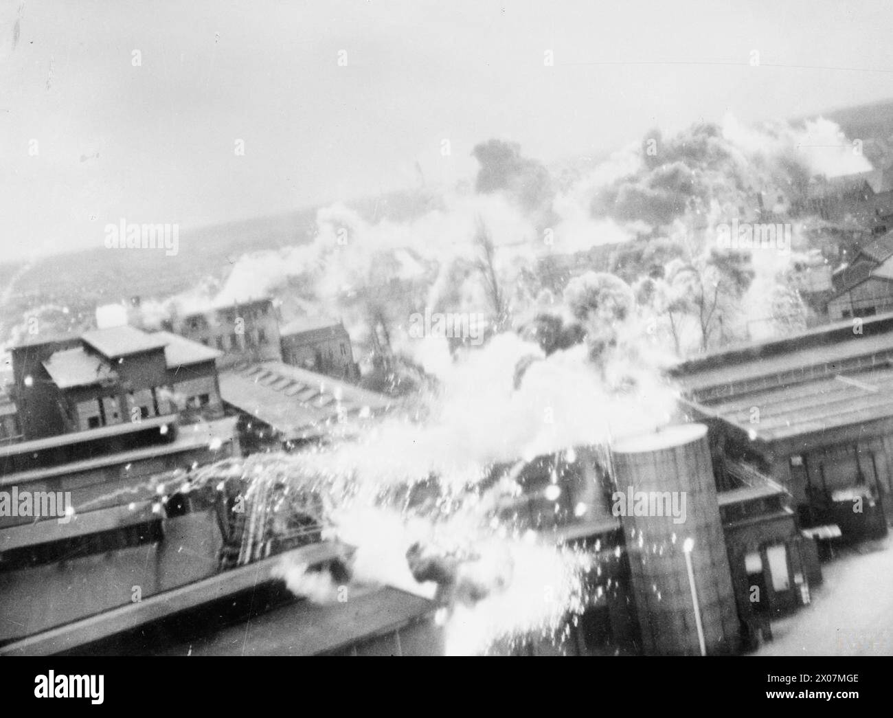 THE STRATEGIC BOMBING OF GERMANY AND OCCUPIED EUROPE, 1942-1945 - Operation OYSTER, the daylight attack on the Philips radio and valve works at Emmasingel, Eindhoven, Holland, by No. 2 Group, 6 December 1942. Low-level oblique photograph showing incendiary bombs dropped by Lockheed Venturas bursting on the roof of the Emmasingel lamp and valve factory  Royal Air Force, 2 Group Stock Photo