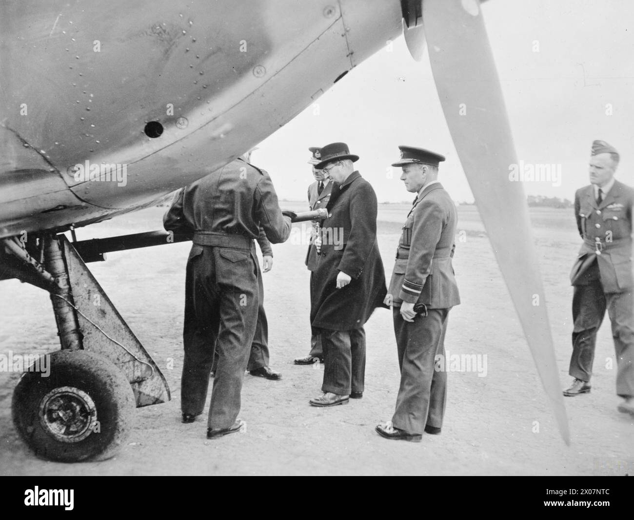 SIR JAMES GRIGG AT TACTICAL AIR FORCE AIRFIELD - The firing powers of a tank buster are explained to Sir James Grigg , Stock Photo