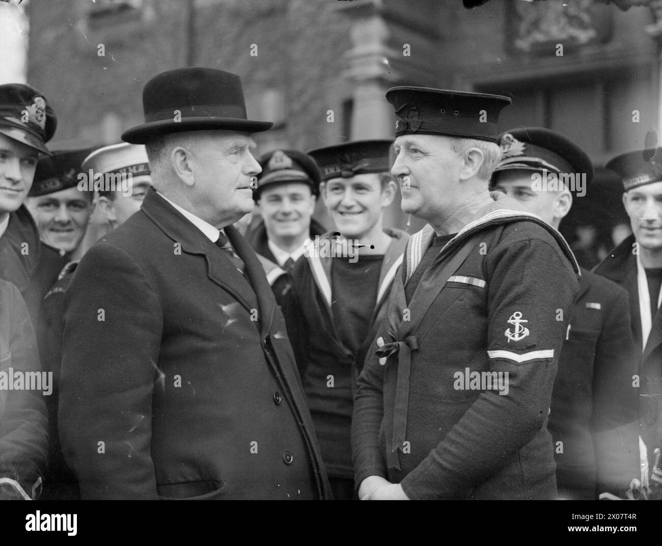 HIGH COMMISSIONER VISITS NEW ZEALANDERS AT PORTSMOUTH. 4 DECEMBER 1943. MR W J JORDAN, NEW ZEALAND HIGH COMMISSIONER, ACCOMPANIED BY MR S R SKINNER, OFFICER FOR NEW ZEALAND NAVAL AFFAIRS IN LONDON, HE MET AND TALKED TO NEW ZEALANDERS SERVING IN HM SHIPS. - Mr Jordan talking to 46 year-old Leading Stoker James Cameron Anson, who left Wellington, New Zealand 20 years ago to go to South Africa, where in 1940 he joined the South African Navy Stock Photo