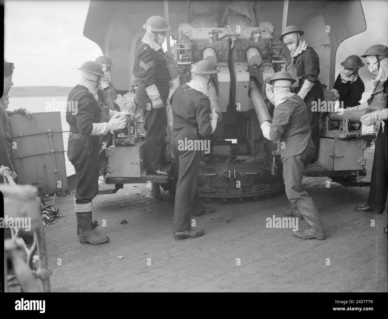 A twin 4-inch gun crew operates aboard HMS Berwick during World War II ...