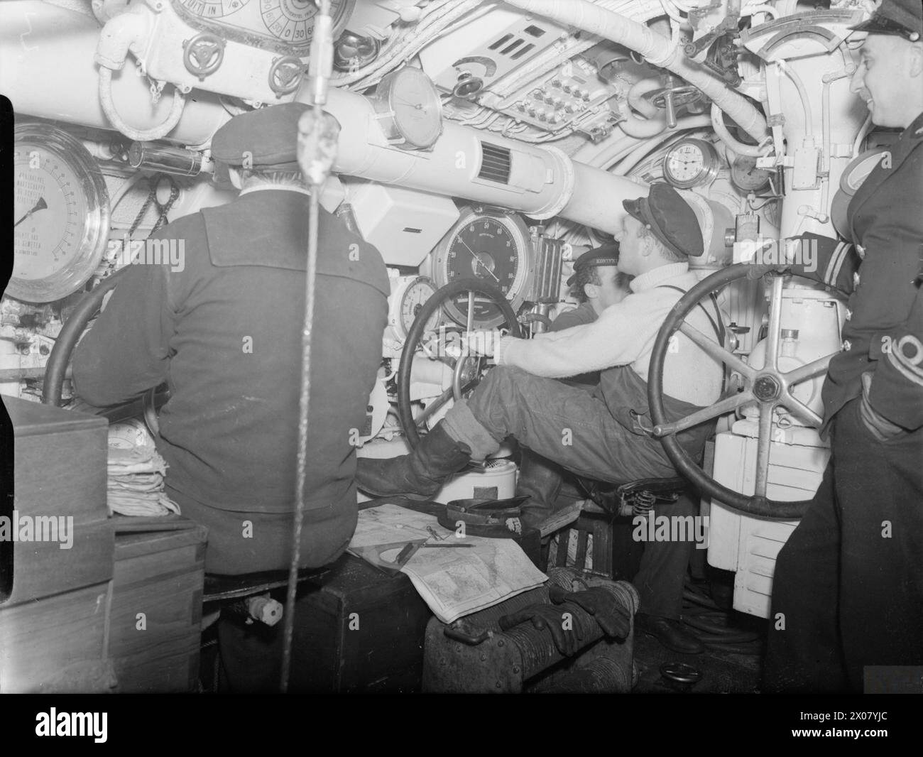 THE ROYAL NAVY DURING THE SECOND WORLD WAR - The Central Control Room, from where diving and surfacing manoeuvres are controlled on board the Dutch submarine O 14. The Hydroplane helmsmen sit in front of their gauges depth-keeping. One of the depth gauges indicates 30 feet. The Chief Engineer is seen right, an Officer in Dutch Submarines, a Chief Petty Officer in British Vessels  Royal Netherlands Navy, O14 Stock Photo