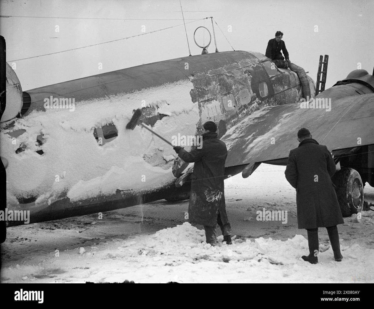 ROYAL AIR FORCE COASTAL COMMAND, 1939-1945. - Groundcrew scraping snow from a Lockheed Hudson of No. 233 Squadron RAF at Thorney Island, Hampshire  Royal Air Force, Maintenance Unit, 235 Stock Photo