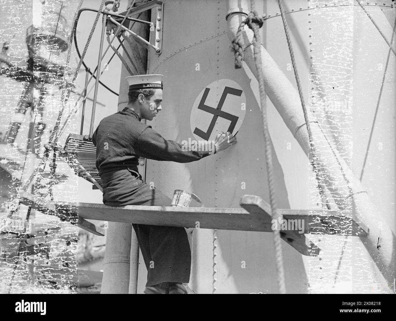 KEEPING THE SCORE: HHMS ADRIAS MARKS UP 1 U-BOAT DESTROYED. MARCH AND APRIL 1943, MERS-EL-KEBIR. - A Greek sailor painting a swastika on the funnel of HHMS ADRIAS, indicating the Greek destroyer's successful part in the U-boat war. On 13 march 1943 she is believed to have sunk a U-boat in the N Atlantic while escorting a convoy Stock Photo