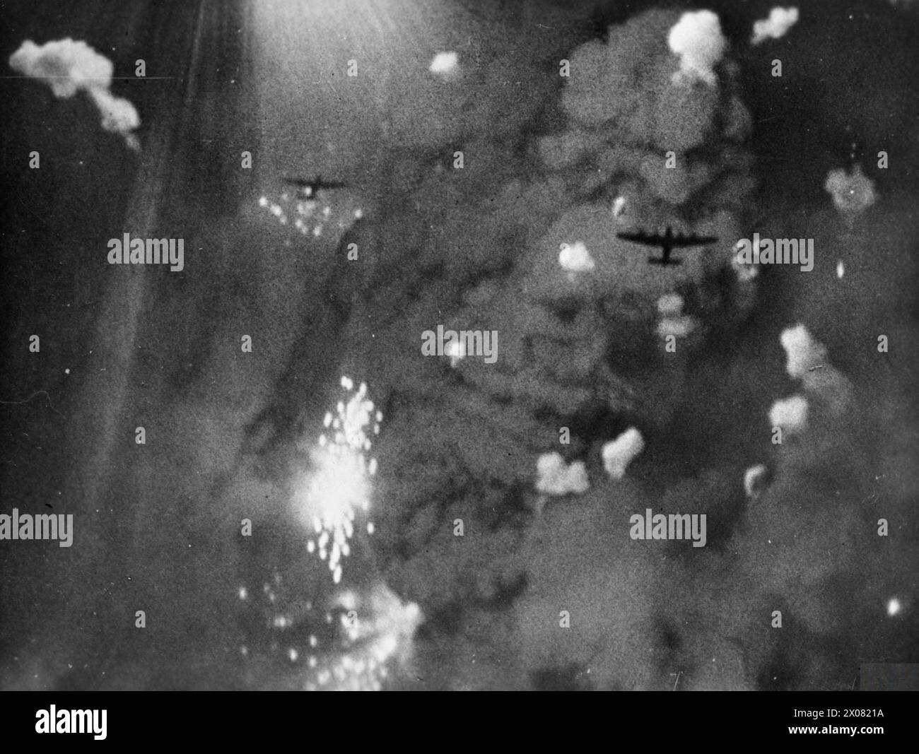 Two Avro Lancaster bombers of RAF Bomber Command over Pforzheim, Germany, during a major area-bombing raid, 1942–1945, captured by RAF Film Production Unit, showing anti-aircraft bursts and target indicators. Stock Photo