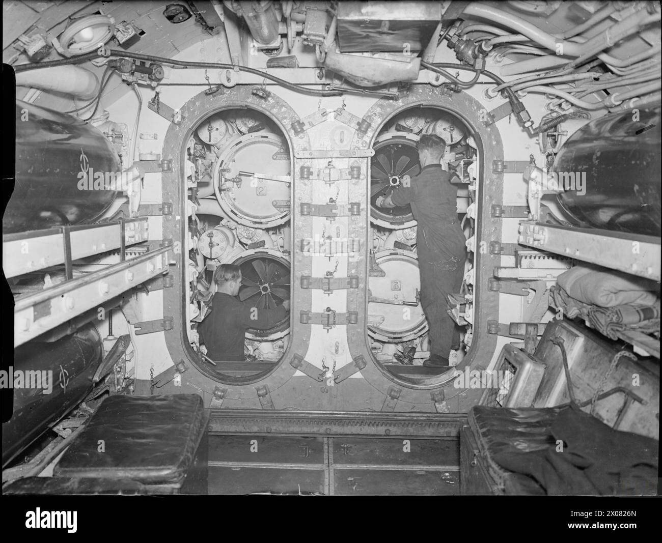 THE ROYAL NAVY DURING THE SECOND WORLD WAR - The torpedo stowage compartment and the forward tubes on board HMS SNAPPER. Two men are working on torpedos in the tubes  Royal Navy, SNAPPER (HMS) Stock Photo